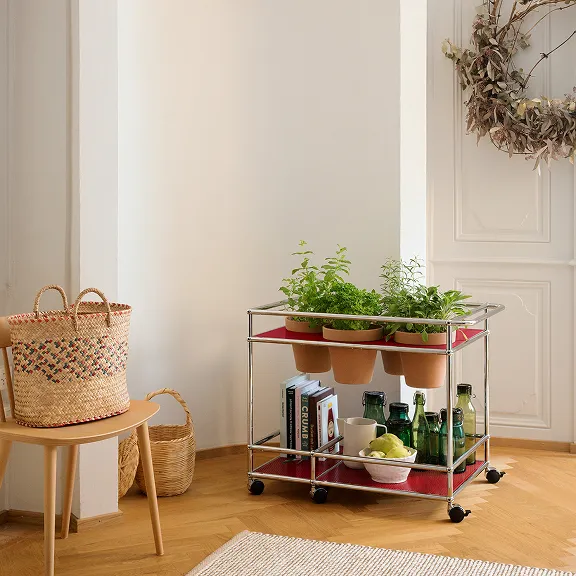 USM Haller Kräuterwagen in Rubinrot. Bestückt mit Terracotta Pflanzentöpfen.